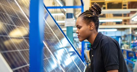 A young woman working on a solar panel