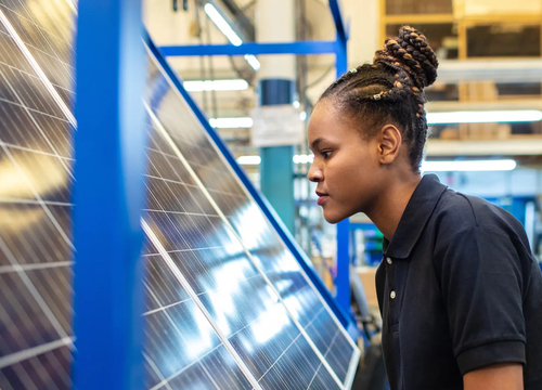 A young woman working on a solar panel