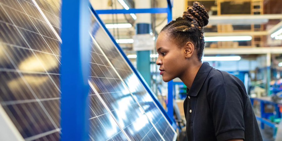 A young woman working on a solar panel
