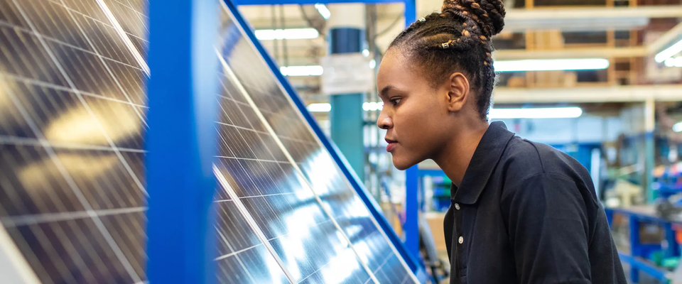 A young woman working on a solar panel
